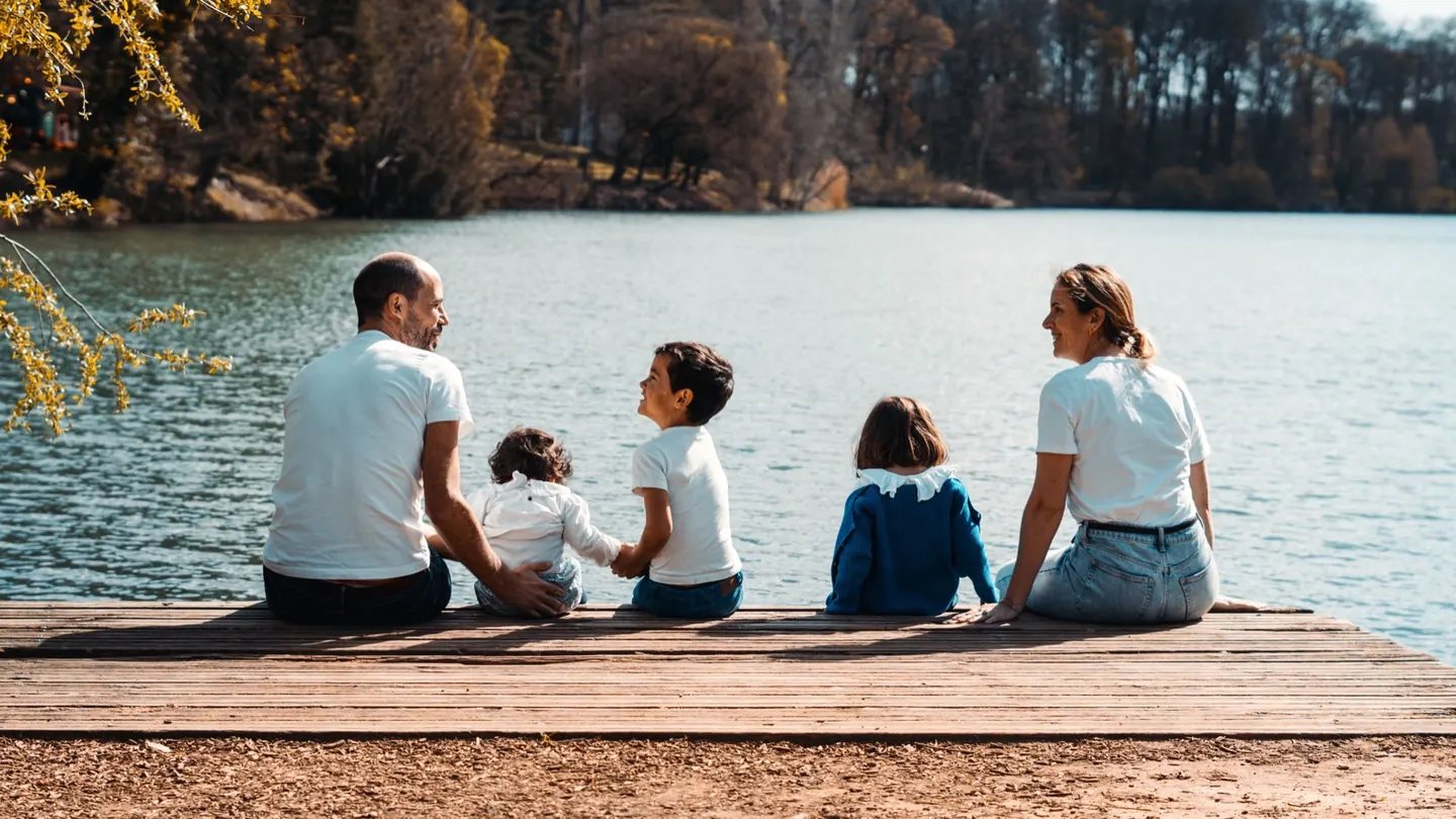 Famille assise au bord d'un lac
